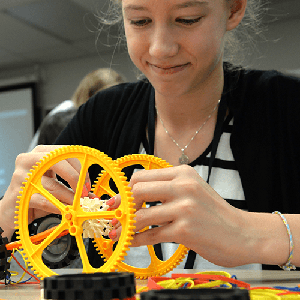 Young student works with Lego gears during camp 